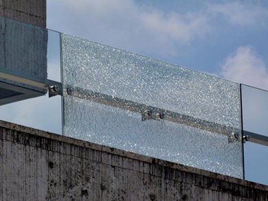 A broken glass railing piece with standoffs.