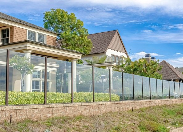 A glass fence on a property’s back perimeter.