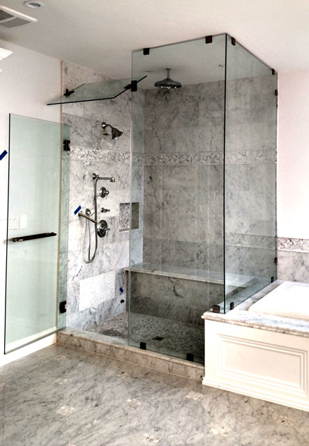 A heavy glass steam unit shower enclosure with a return panel and oil rubbed bronze hardware.