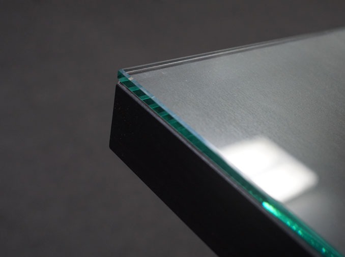 A glass tabletop protector with flat polished edge-work on an office desk.